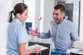 man yelling at a woman behind a desk