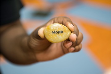 MBSR-hope hand holding stone with the word hope