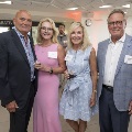 Four people posing for a picture in the suite