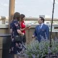 Three people talking together in the garden with plants in the foreground