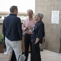 Three people standing conversing in the garden