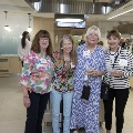 Four women post with the kitchen in the background