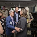 A man and a women embrace arms with other people smiling around them