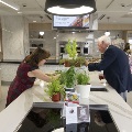 Two people looking at herbs in a kitchen