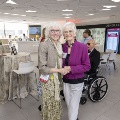 Two women hold hands while posing for a picture