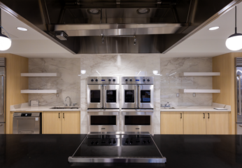 view of the john and carrie hayden community learning kitchen from the shared countertop looking at ovens