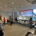 Group of people doing tai chi and watching screen presentation