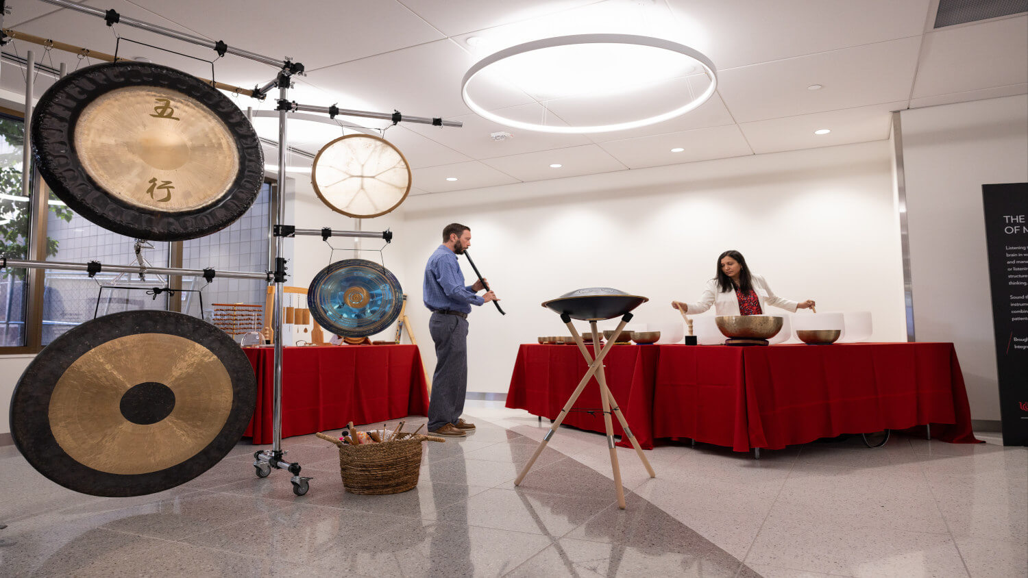 two people performing sound immersion with gongs, sound bowls, and flutes