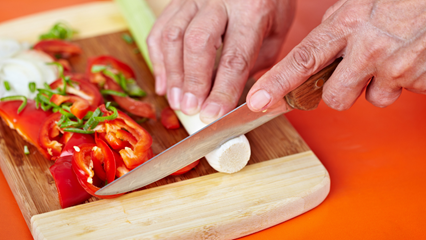 hands holding knife chopping vegetables