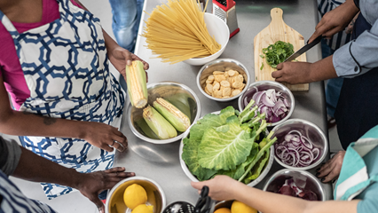 hands holding healthy food in bowls at a teaching kitchen event