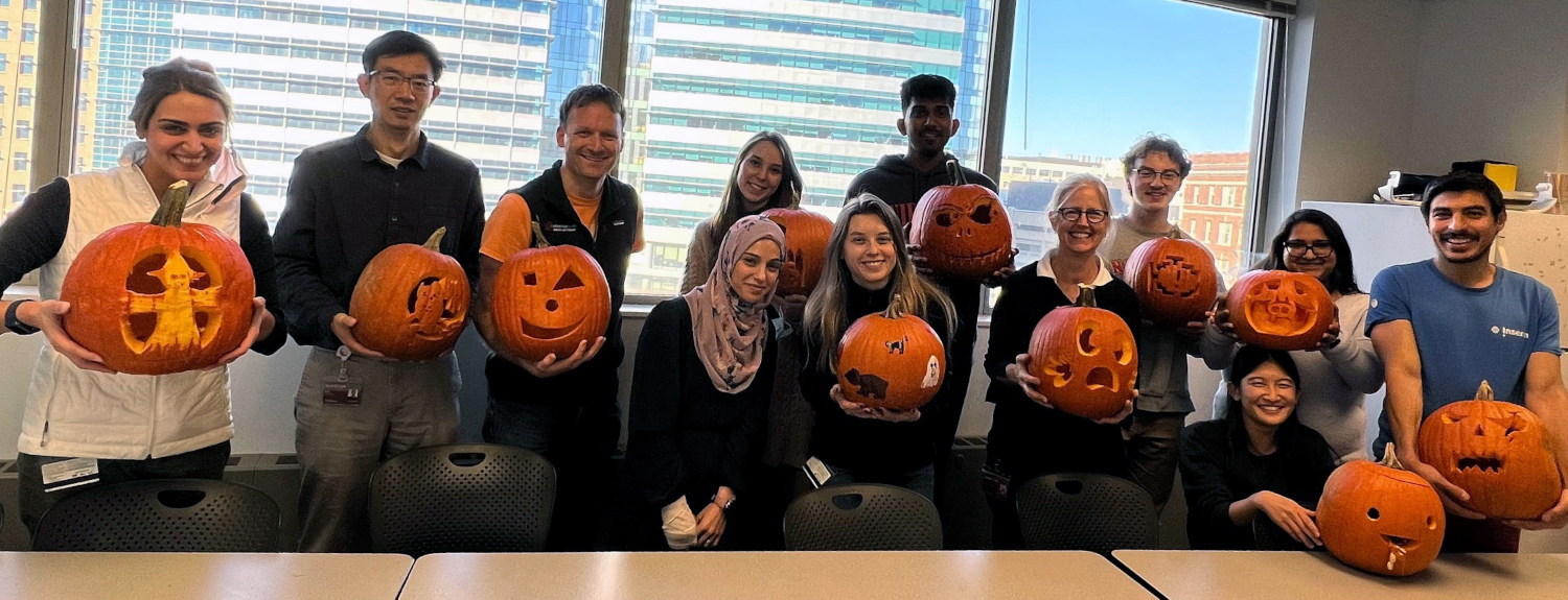 Member of group holding carved pumpkins